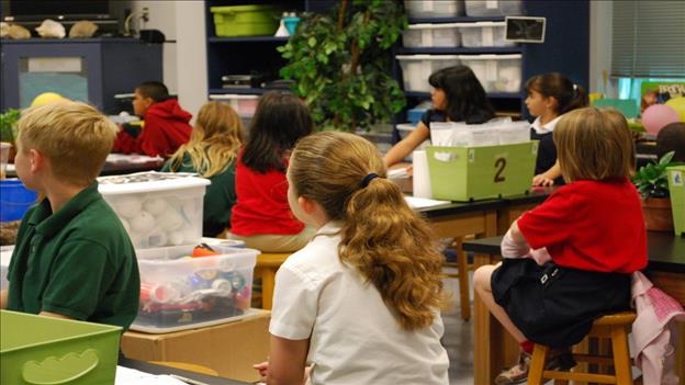 school children sitting at their desks in classroom